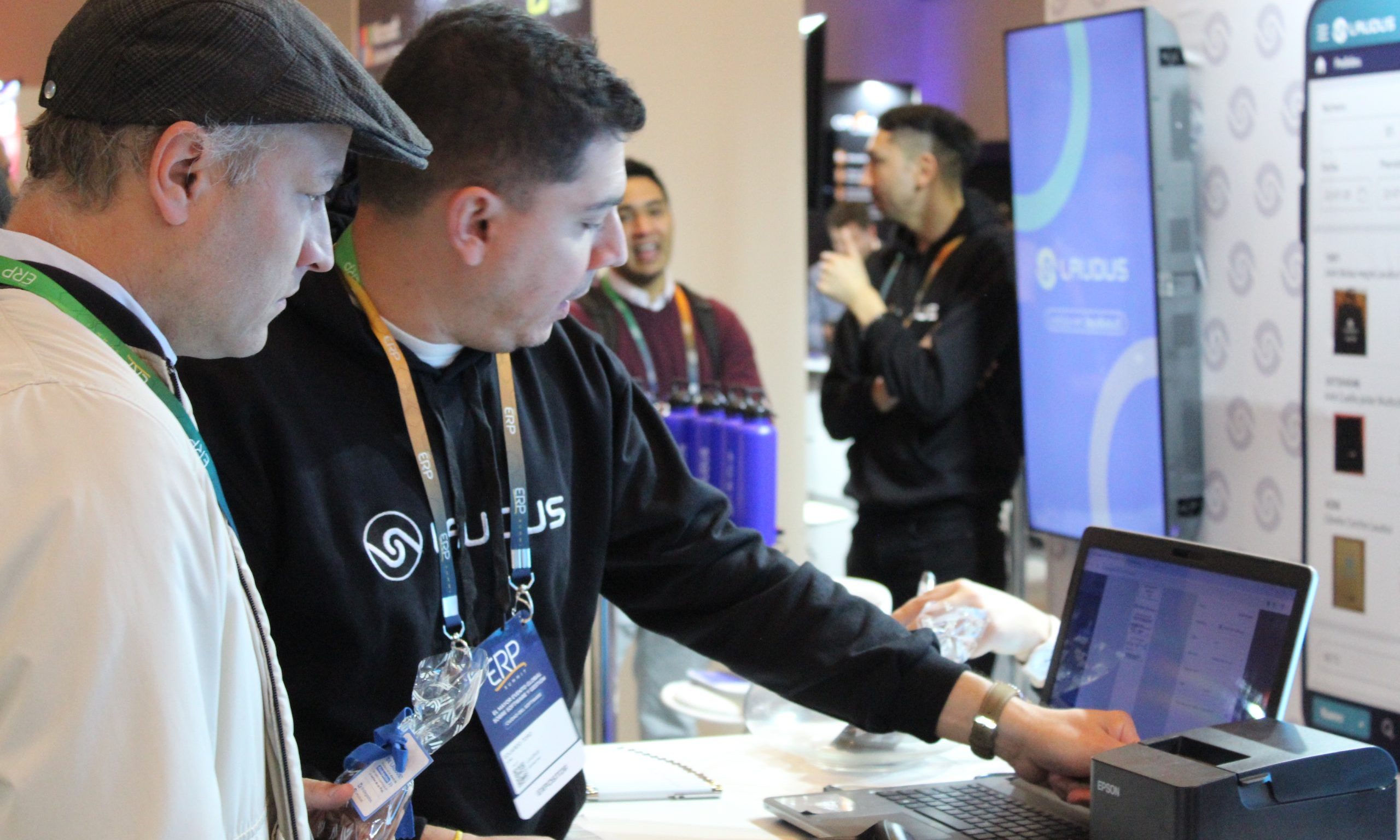 Ejecutivo de Laudus demostrando el software ERP a un asistente en el ERP Summit Chile 2025.
